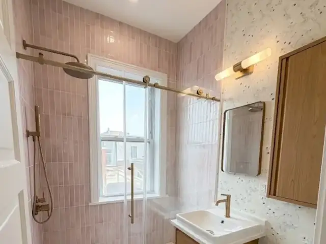 Logan Square three-flat bathroom in Chicago with pink zellige walk-in shower, brushed gold fixtures and oak vanity