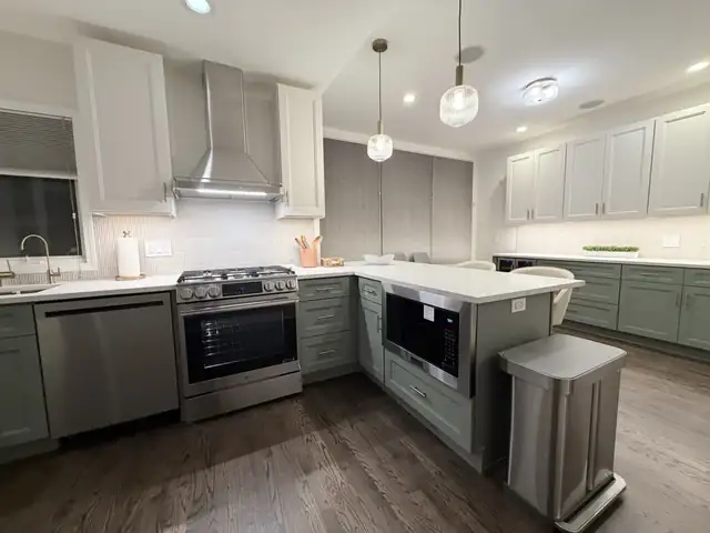Bucktown kitchen remodel at 1757 N Paulina St with two-tone green and cream cabinetry, Calacatta quartz and fluted tile backsplash