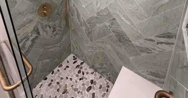 West Loop townhouse bathroom at 664 N Green in Chicago with green marble herringbone shower and brass fixtures